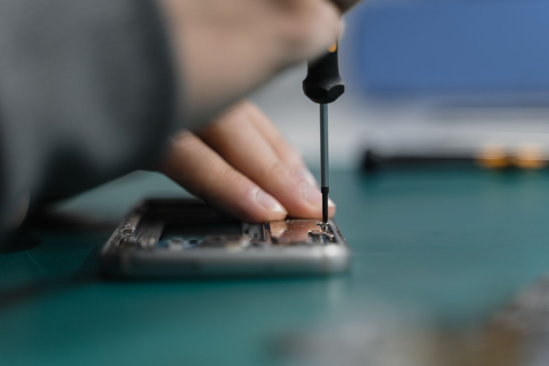Reparateur vervangt met een precisieschroevendraaier een onderdeel in een smartphone
